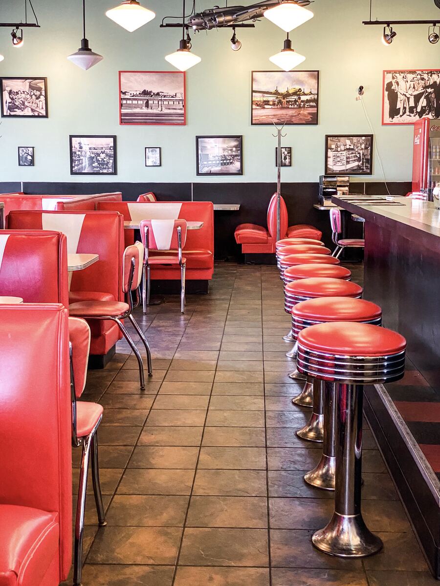 Red booths and chrome counter stools inside Avalon Diner