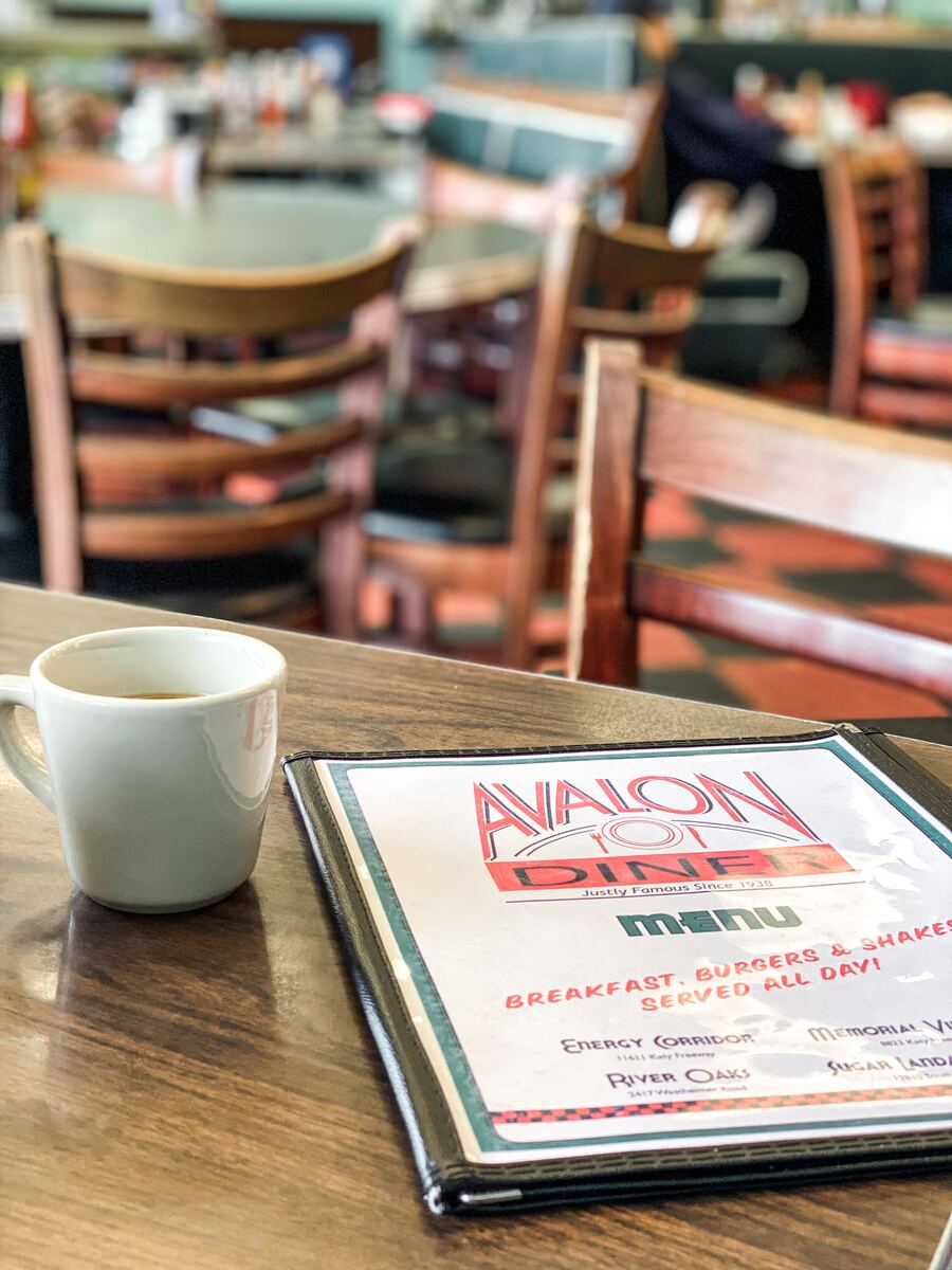 Avalon Diner menu on a table with a cup of coffee